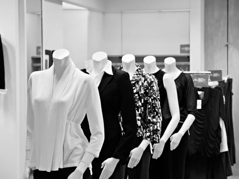 Manequins vestidos em arara de roupas dentro de loja