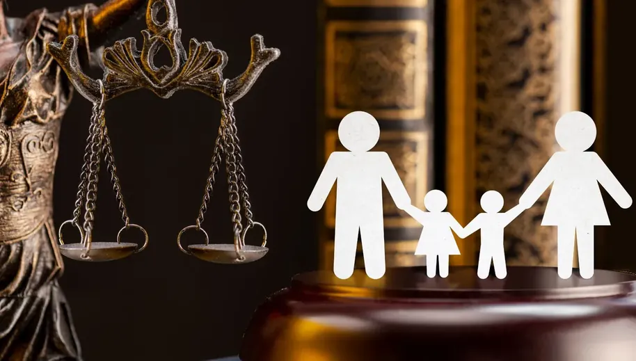 Recorte de papel em forma de família ao lado de uma balança da justiça